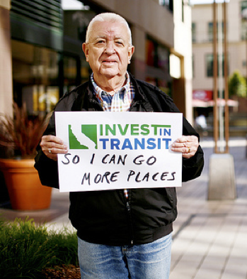 Man holding sign in support of transit