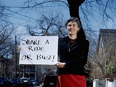 Person holding sign: "Share a ride or bust."